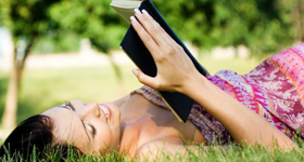 Young woman enjoying the outdoors reading a book